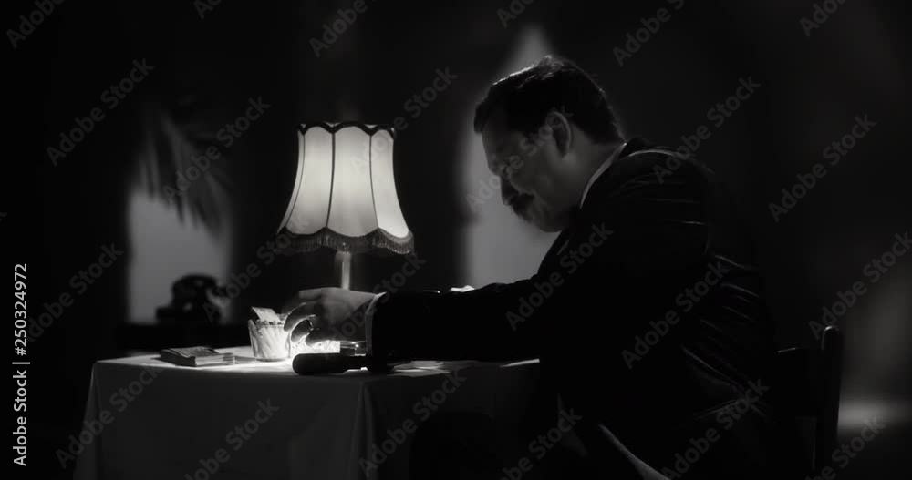 Gentleman taking a sip from his fancy whiskey glass as he is writing