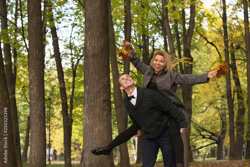 Happy young couple playing with fallen leaves in autumn park Happy young couple playing with fallen leaves in autumn park