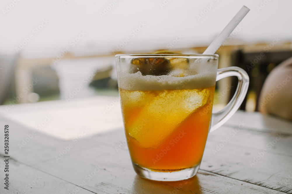 Cold ice tea with dried citrus fruits and cocktail straw tube in the glass Cold ice tea with dried citrus fruits and cocktail straw tube in the glass