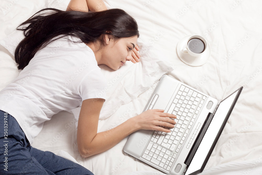 young beautiful woman using laptop in bed young beautiful woman using laptop in bed
