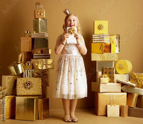 Принти на полотні happy young girl looking out from tablet PC with bow