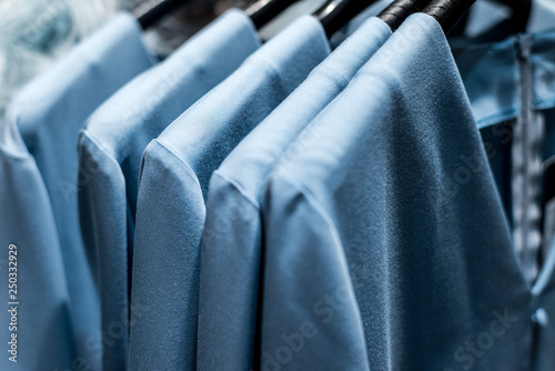 Blue clothes hanging on store racks