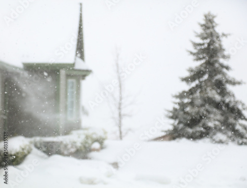 A blizzard in the mountains with snow blowing off of the roof. © cpdprints
