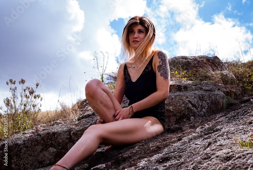 young woman sitting on a rock