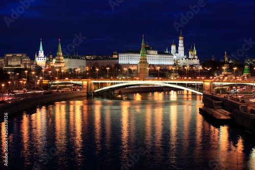 Beautiful night view of the Moscow Kremlin and the bridge over the river with the reflection of lights in the water, Russia