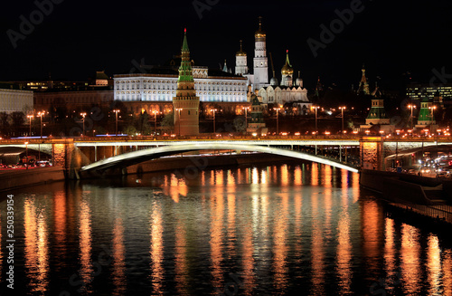 Beautiful night view of the Moscow Kremlin and the bridge over the river with the reflection of lights in the water, Russia