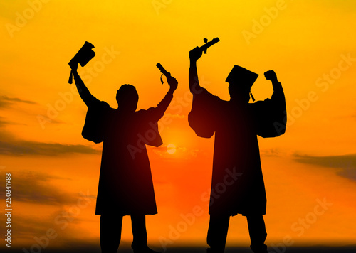 Silhouette of Student Graduation. They are seeing sunset. They are standing and show hand.They are celebration in Graduate , Education,academic, Photo concept Silhouette and Success