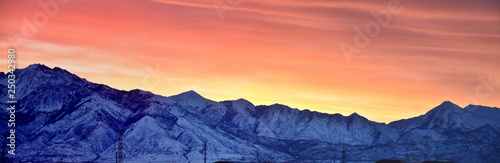 Sunrise of Winter panoramic, view of Snow capped Wasatch Front Rocky Mountains, Great Salt Lake Valley and Cloudscape from the Mountain view Corridor Highway. Utah, USA.