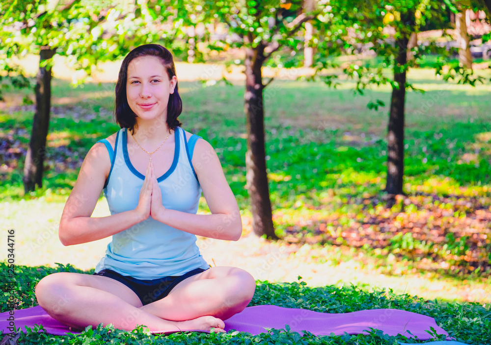 She is yoga in park.She is sitting on mat and doing yoga in morning.relax time and good health. Photo concept yoga and good health. 