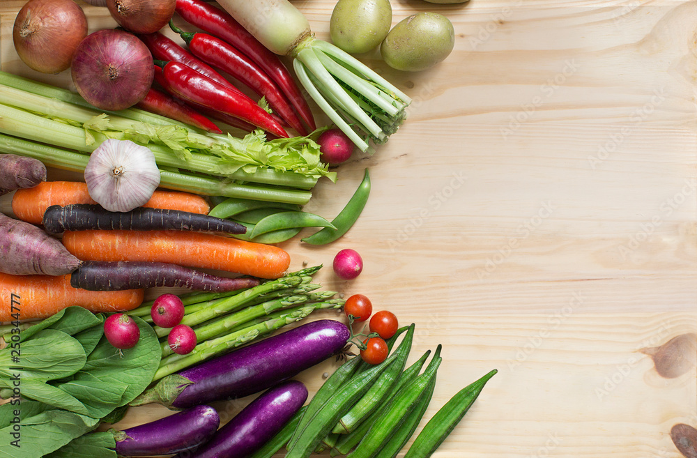 Flat lay view of different colourful raw vegan food on wooden background. Flat lay view of different colourful raw vegan food on wooden background.