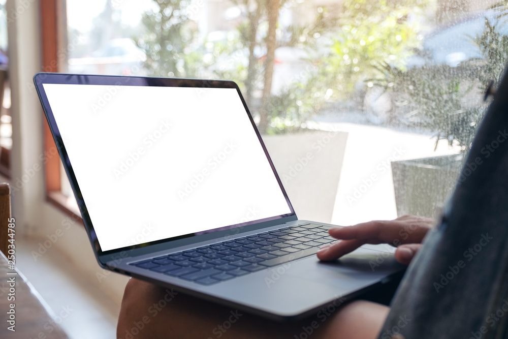 Closeup image of hand using and touching on mockup laptop touchpad while sitting indoors Closeup image of hand using and touching on mockup laptop touchpad while sitting indoors