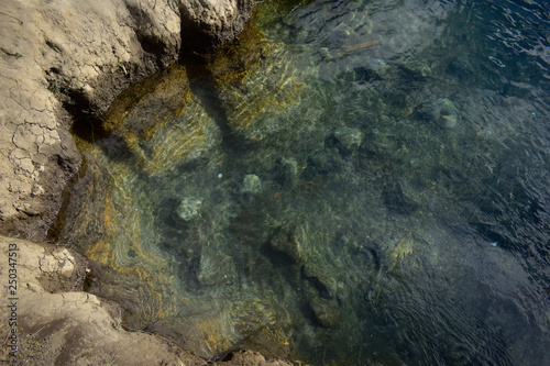 las aguas transparentes de un arroyo dejan ver el fondo en la costa