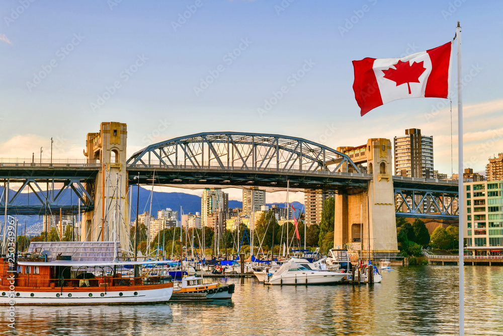 Fototapeta premium Prom zacumował na wyspie Granville w pobliżu mostu Burrard Street Bridge o zmierzchu w Vancouver w Kanadzie