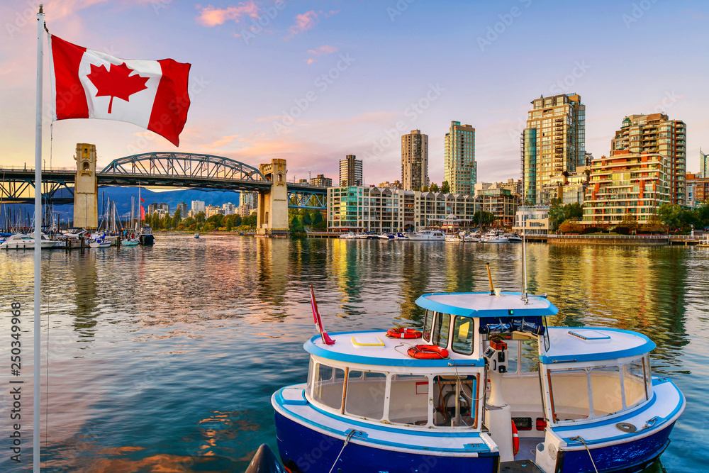 Obraz premium Prom zacumował na wyspie Granville w pobliżu mostu Burrard Street Bridge o zmierzchu w Vancouver w Kanadzie
