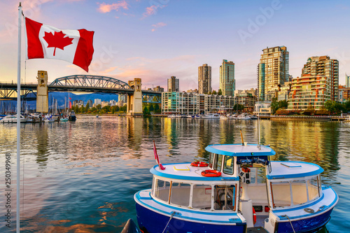 Ferry boat docked along in Granville island near Burrard Street Bridge at twilight in Vancouver,Canada photo