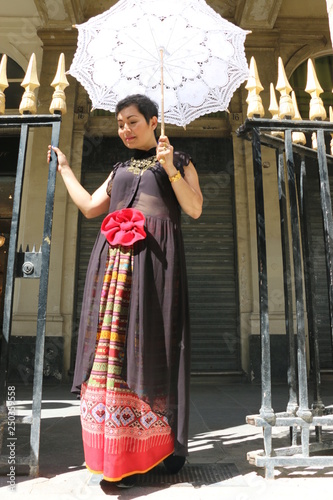 Wallpaper Mural Femme avec ombrelle blanche regardant à terre devant les grilles du palais royal à Paris Torontodigital.ca