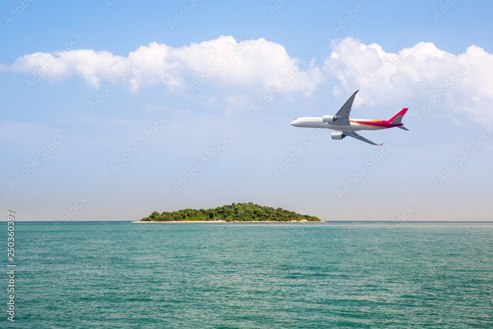 passenger plane flying over beautiful blue ocean and island sea beach use for summer holiday vacation traveling . Airplane flying over amazing ocean landscape with tropical island.