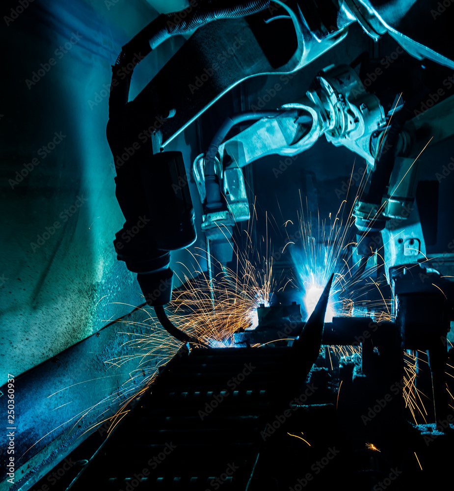 Motion Welding robots in a car factory with sparks Motion Welding robots in a car factory with sparks