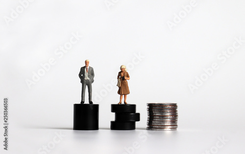 Equal labor equal pay concept. Miniature woman with a miniature man. #PayMeToo as social new movement.