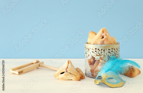 Purim celebration concept (jewish carnival holiday) over wooden table