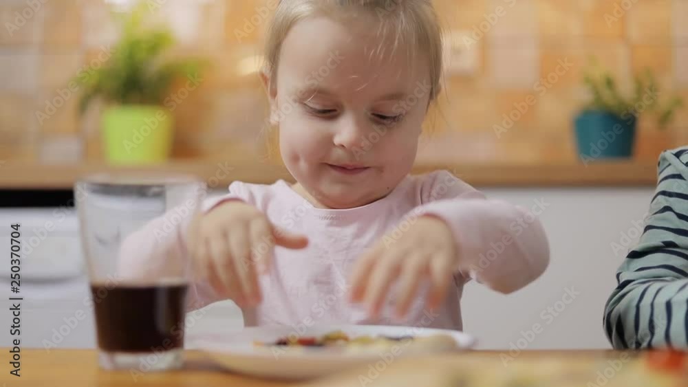 Beautiful happy cute baby girl eating slice of homemade pizza. Beautiful happy cute baby girl eating slice of homemade pizza.
