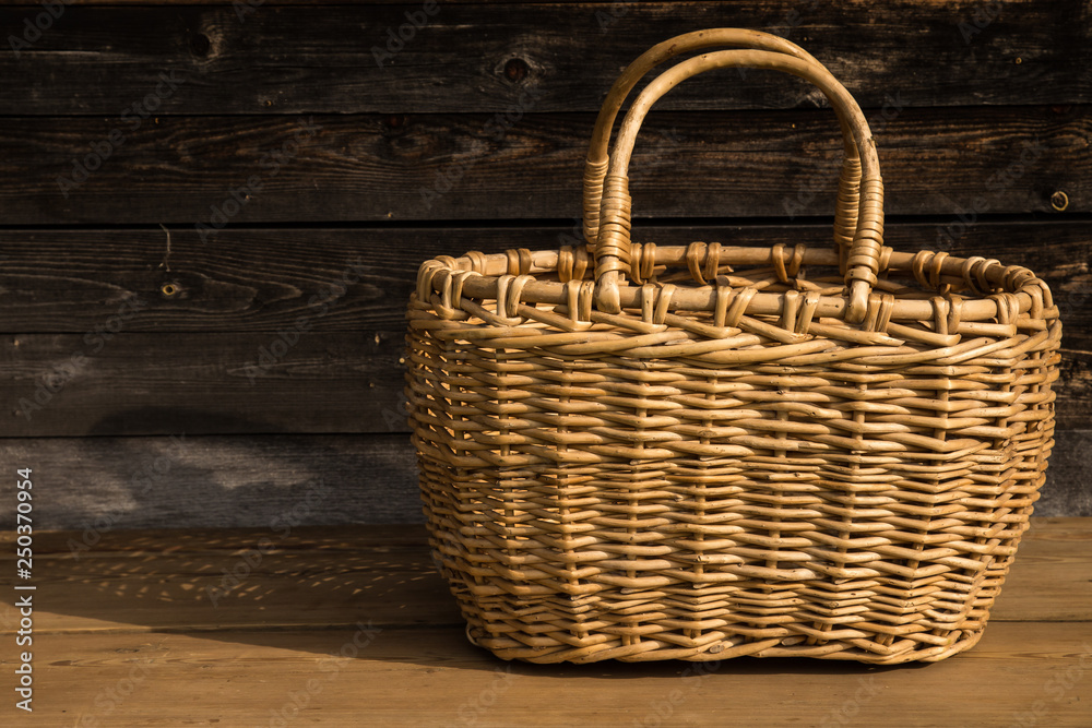 Ancient wicker basket on a wooden background. Selective focus. Free space for text.