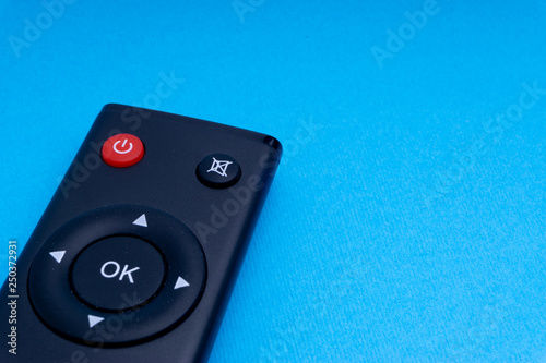 Remote control TV or radio isolated on blue background with selective focus and crop fragment
