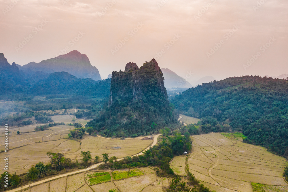 (View from above) Stunning aerial view of a beautiful limestone mountain at sunset in Vang Vieng, Laos.