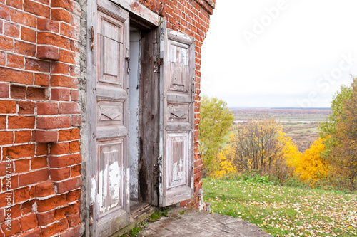 A wooden double door in an old abandoned house. One door leaf is open. Rukavishnikov manor in the village of Podviazye, Bogorodsky District.