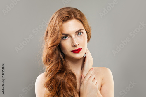 Woman model natural, healthy skin with freckles and long red curly