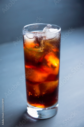 Cold cola beverage in glass with ice. Selective focus. Shallow depth of field.