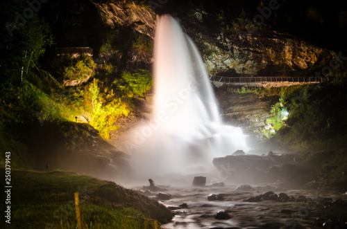 Beautiful waterfall Steinsdalsfossen in Norway shining lit up in the night