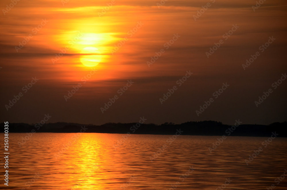 Sunset over the sea with a misty sky and warm colors. Sunset over the sea with a misty sky and warm colors.