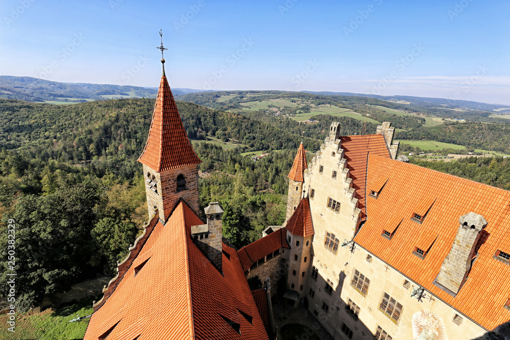 Buildings of Bouzov castle from above with woods in background