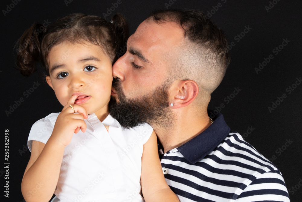 father and daughter kiss hug in black background father and daughter kiss hug in black background