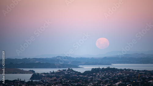 Full moon rising above Auckland, with moonrise and sunset at the same time, viewed from Mount Eden