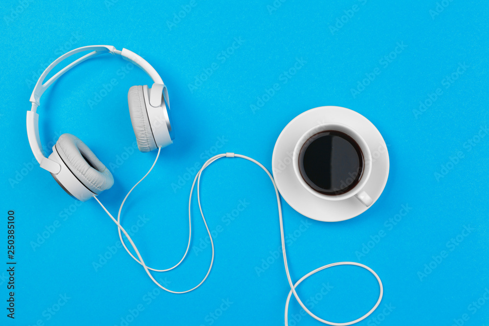 Headphones and coffee cup on blue background, top view - obrazy, fototapety, plakaty 