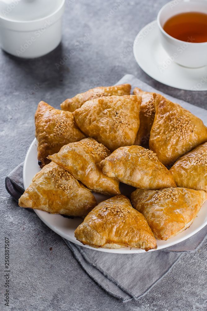 Plate with delicious samosas samsa with meat on gray background, top view. Uzbek food Plate with delicious samosas samsa with meat on gray background, top view. Uzbek food