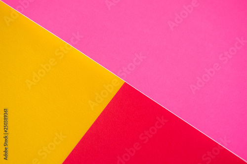 Textured triangles of yellow, red and pink colors. Design paper.