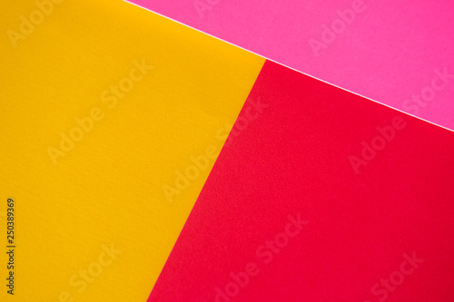 Textured triangles of yellow, red and pink colors. Design paper.