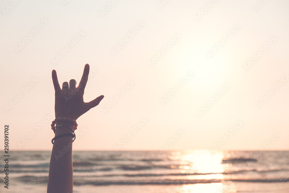 ILY I love you hand sign  symbol in afternoon sunset sky and sea.