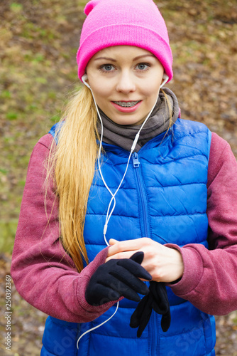 Teenage sporty girl listening to music outdoor.