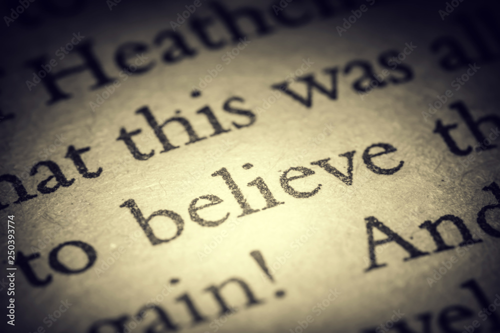 The word believe on old page in a open book close-up macro. Vintage, grunge, old, retro style photo. The word believe on old page in a open book close-up macro. Vintage, grunge, old, retro style photo.