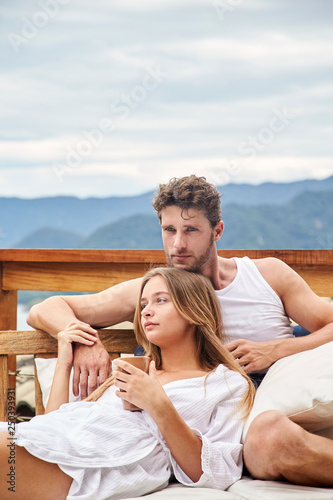 Restring young couple reclining on balcony