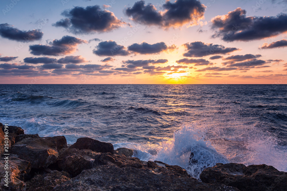 Beautiful bright sunset on the sea, rocky shore