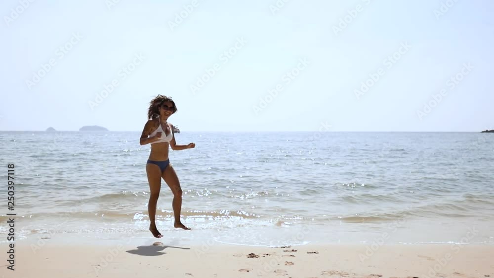 Attractive brunette girl runs along the seashore, enjoys nature Attractive brunette girl runs along the seashore, enjoys nature