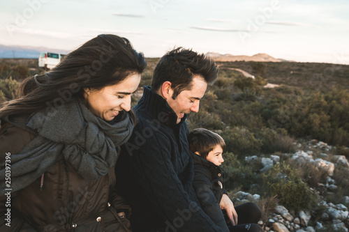 Portrait of a family smiling and happy in the countryside. Marriage with one child in the field