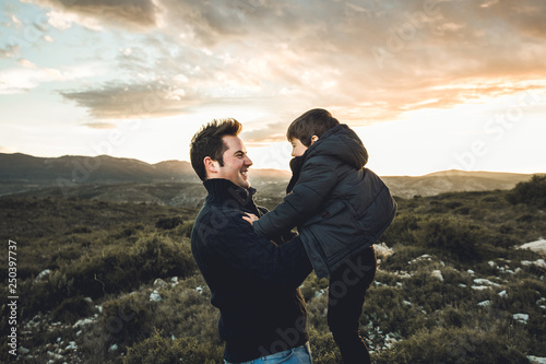 Father throwing his son into the air. Concept of happiness and joy between dad and child