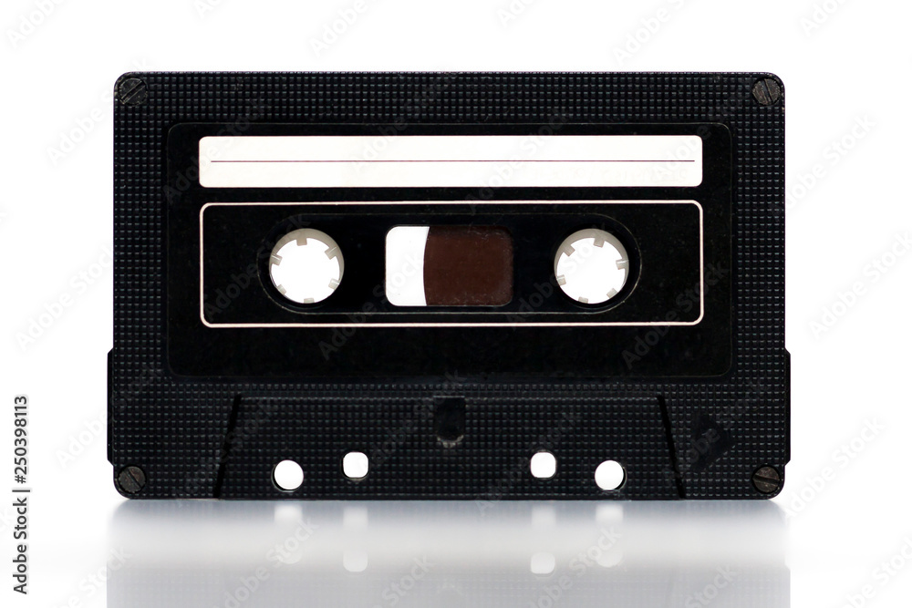Old vintage black cassette with blank white label on white background. Copy space.