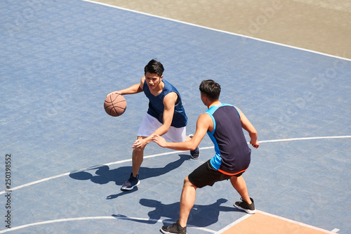 high angle view of young asian adults playing basketball outdoors © imtmphoto